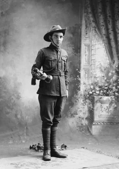 Studio portrait of a young man in an army style uniform.  Family name Edwards.