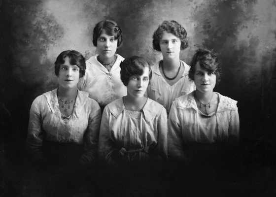 Studio group portrait of five young women.