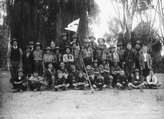 A posed group of boy scouts in a park.