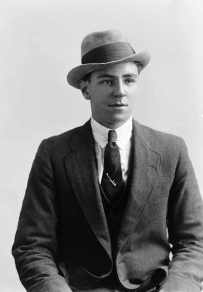 Studio portrait of a young man wearing a trilby hat.  Family name White.