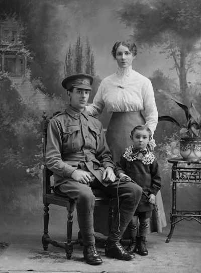 Studio group portrait of a seated man, with a women and boy standing alongside.  Family name Shimmin or Shimmer.