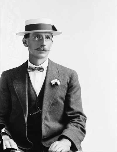 Portrait of a a man in a boater hat and bow tie. Family name Blair.