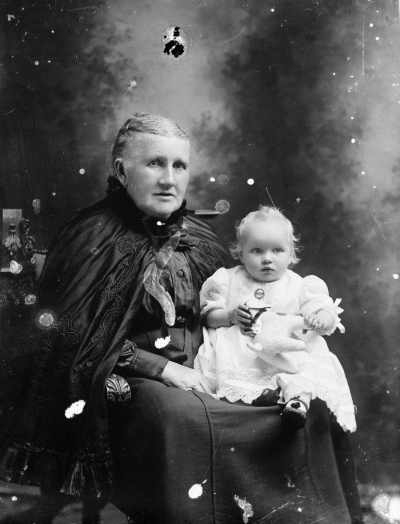 Studio portrait of an elderly woman with a baby.