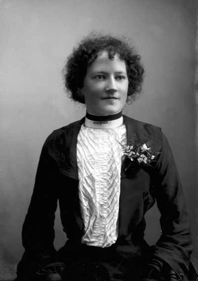 Portrait of  Miss Bell wearing a corsage.
