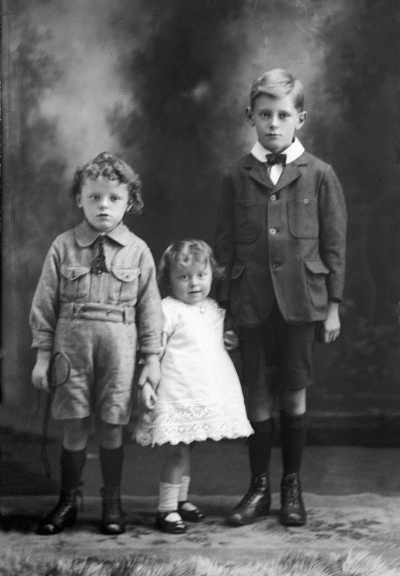 Studio portrait of a group of three children.   Family name Hopper