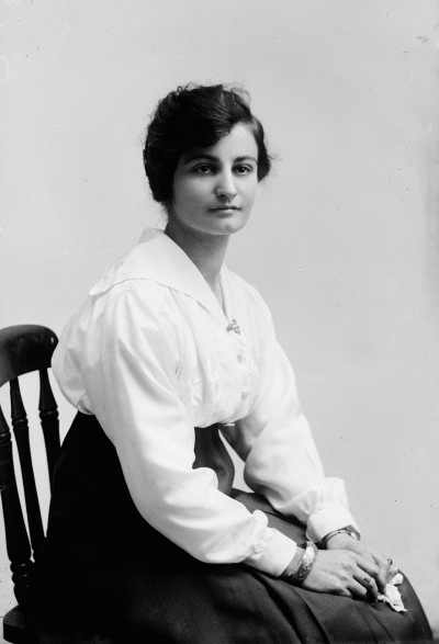 Portrait of a seated young woman wearing a white blouse.