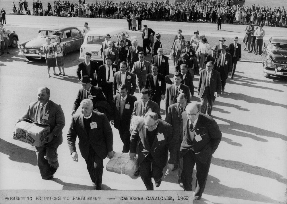A group of men at Parliament House, Canberra presenting Peace Petitions to Parliament, during the "Canberra Cavalcade" in 1962.