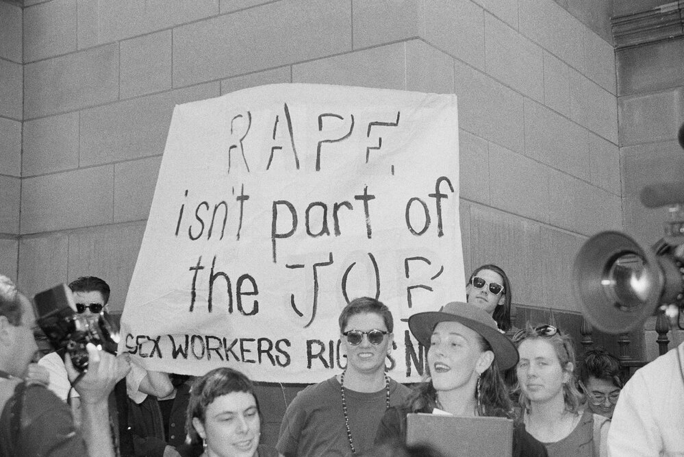 "Rape isn't part of the job, sex workers' rights now" banner at the Prostitutes' Collective demonstration, January 1992.