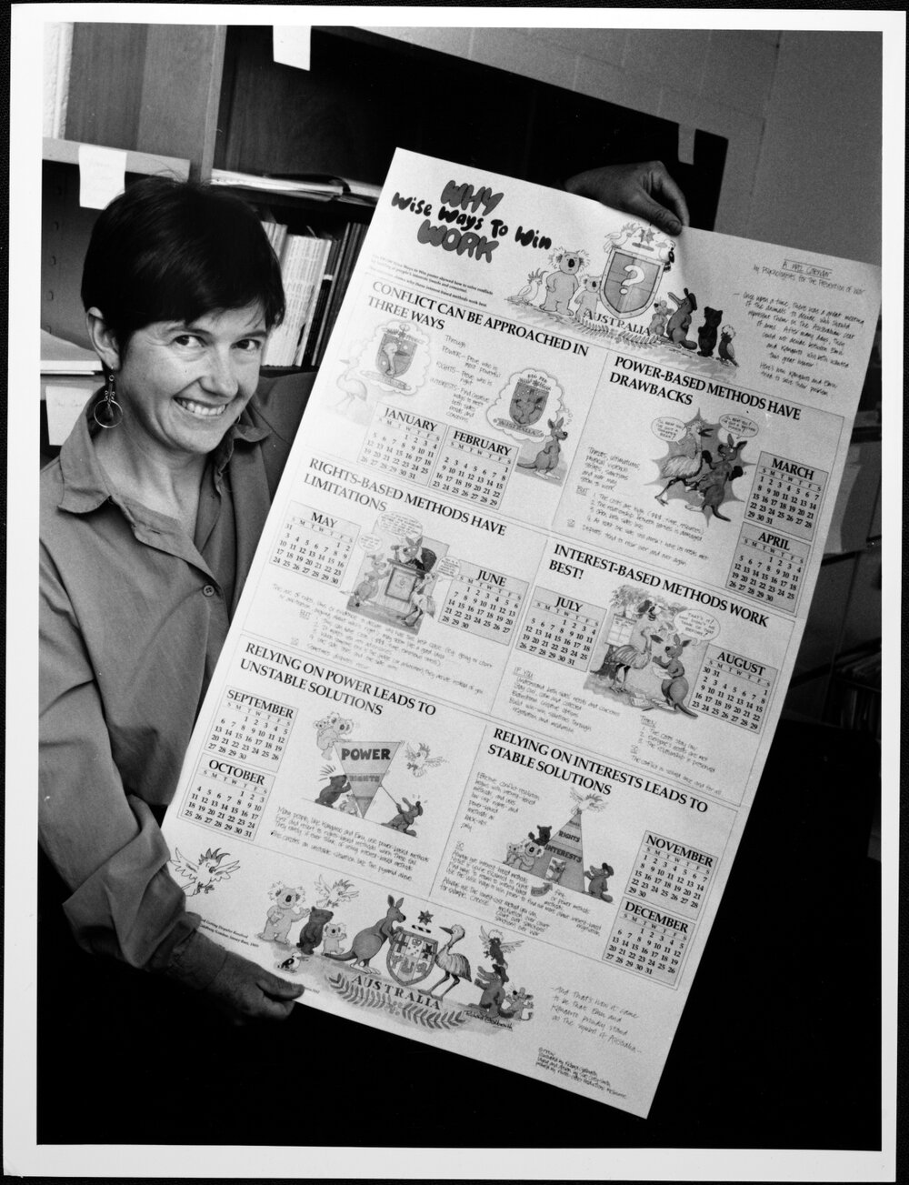 Sanson, Dr Ann, Psychology, holding a 1992 calendar from Psychologists for the Prevention of War (PPOW)
