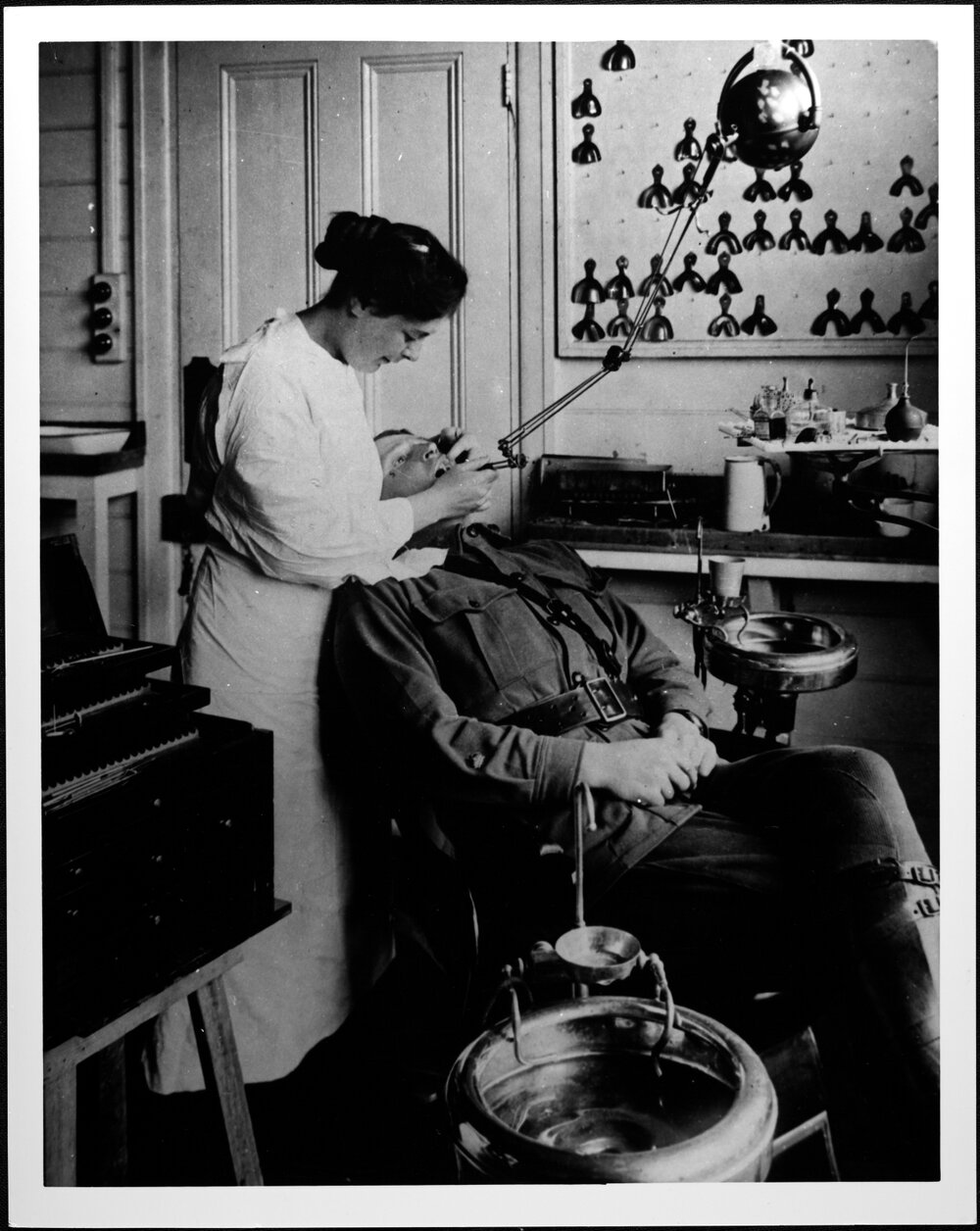 Female carrying out dental treatment on a soldier