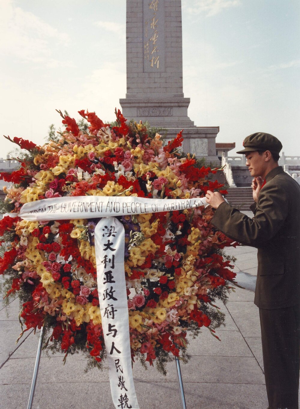 A Chinese soldier attaching a banner to an Australian wreath in front of the Monument to the People's Heroes in Tiananmen Square, Beijing, China.