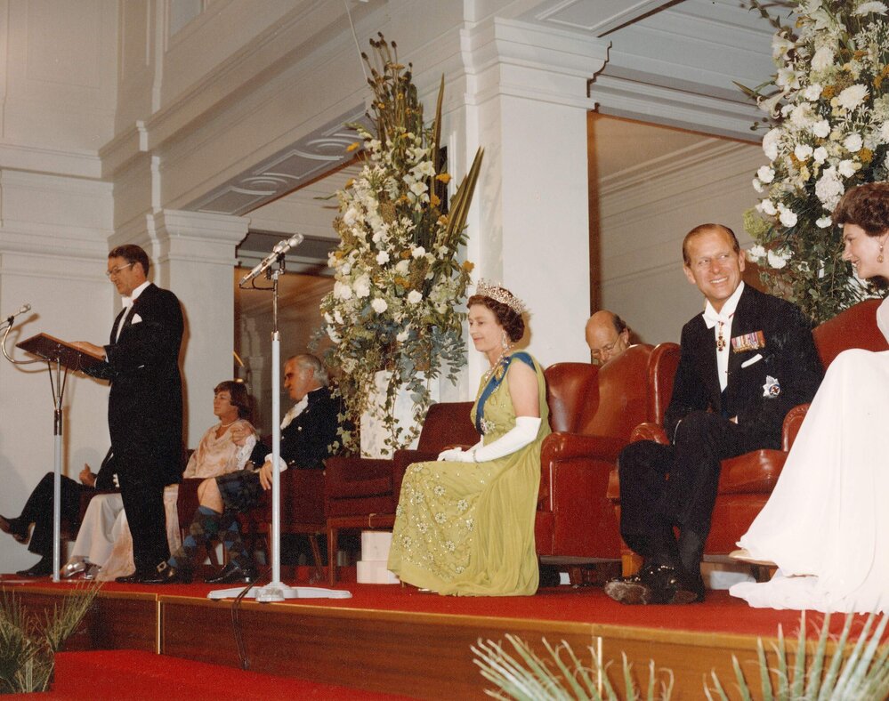 Prime Minister Malcolm Fraser speaking at a lectern at Old Parliament House in Canberra, in the presence of Queen Elizabeth II, the Duke of Edinburgh and Tamie Fraser during the Queen's 1977 official visit.