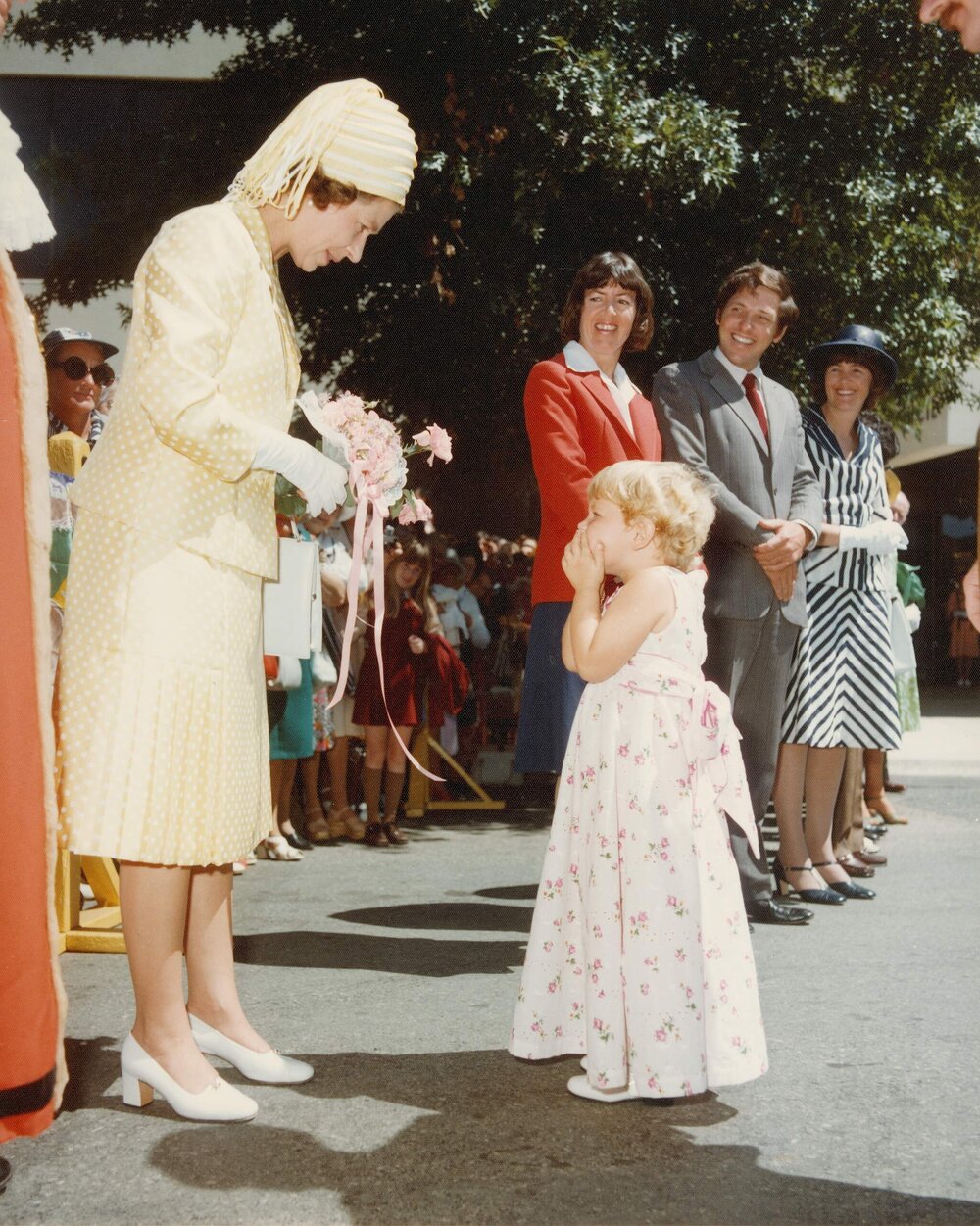Queen Elizabeth II accepting a bouquet of flowers from a small girl at Queanbeyan during her 1977 official visit to Australia.