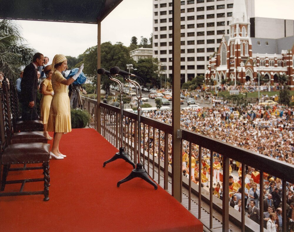 Queen Elizabeth II standing on the balcony of Brisbane City Hall waving to a crowd gathered below in King George Square, during her 1977 official visit to Australia.