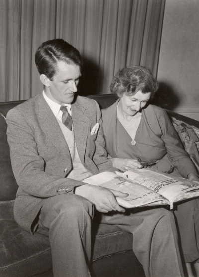 Malcolm Fraser looking at a book of newspaper cuttings with his mother, Una Fraser.