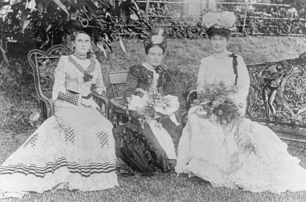 3 unidentified women in a garden setting