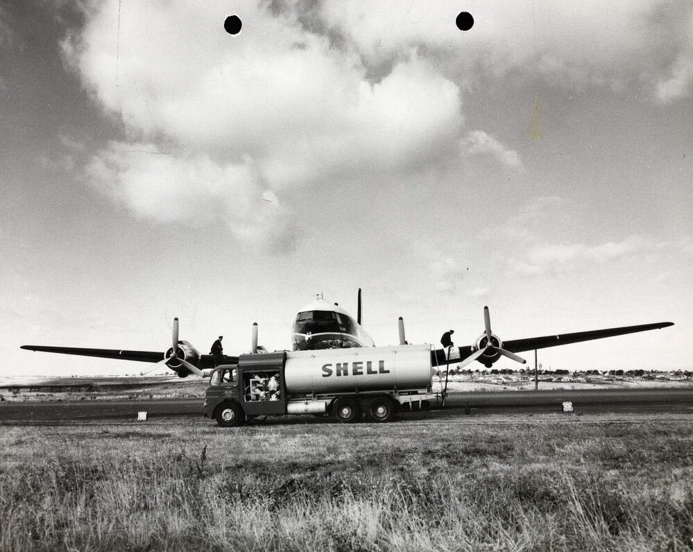 A Shell pump tanker with two men refuelling a possible Ansett-ANA or Trans Australian Airlines, U