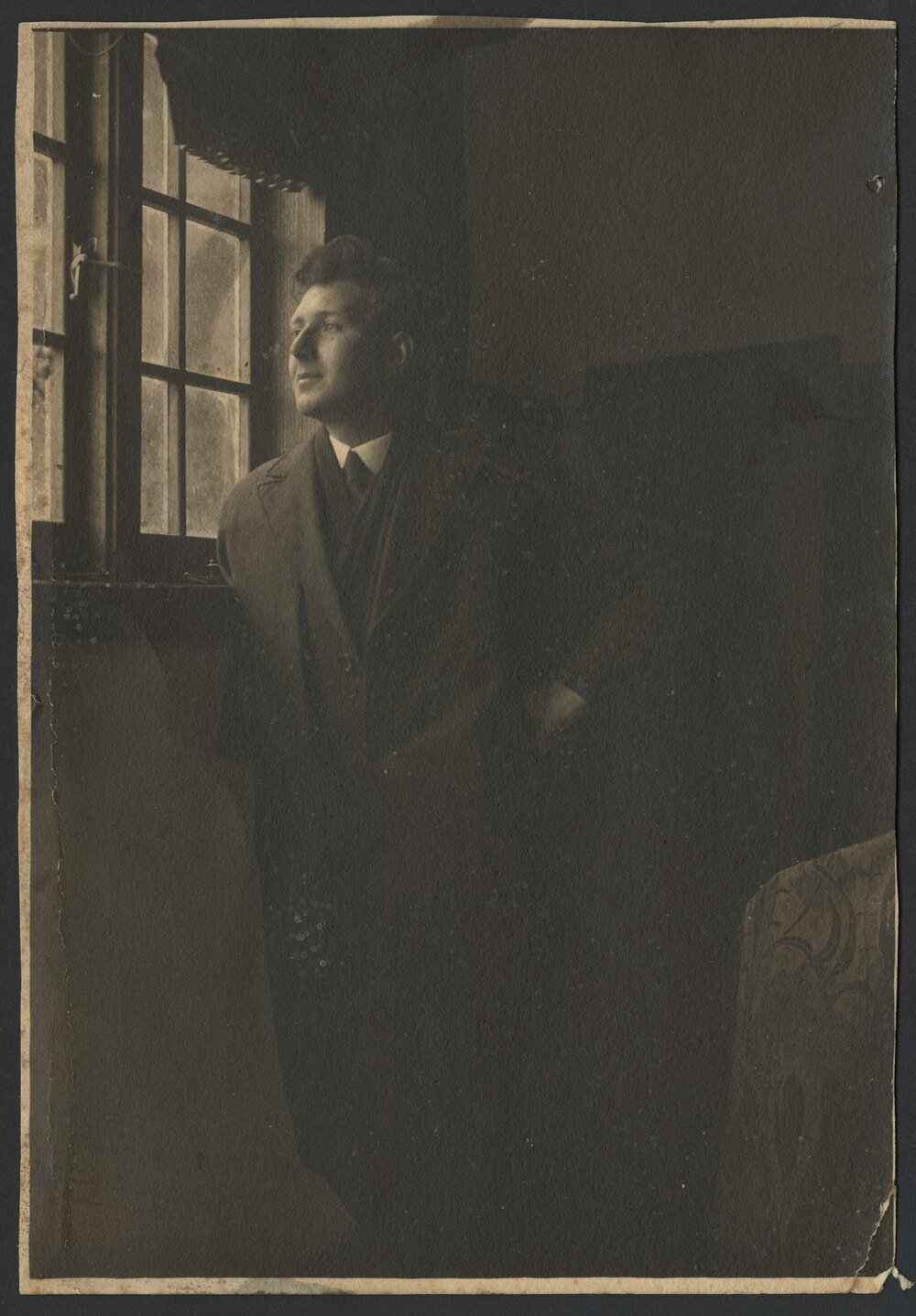 Napier Waller standing, gazing out window