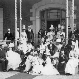 Group photo of men and women standing under the verandah of the Purrumbete homestead