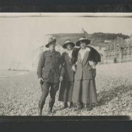 Man in WWI Australian Army uniform and two women standing on beach shore