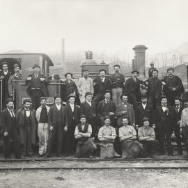 A group of men in front of a locomotive at Mount Lyell Mine site in Tasmania.