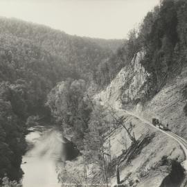 A view of the King River, Tasmania and a locomotive on newly laid tracks alongside.  Extensive new earth works are visible.  Part of the operations of the Mount Lyell Mining & Railway Co. Ltd.