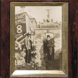 Benjamin Douglass and friend standing under home-built Eight Hours Day monument, inscribed "Labor Triumphos".