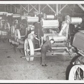 Factory interior of workers assembling agricultural machinery.