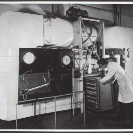 Experimental dehydrator used in developing methods of dehydrating fruit and vegetables, a truck carrying trays of sliced onion is shown being wheeled into the operating section