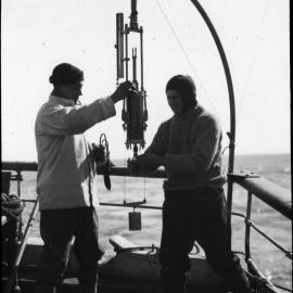 Nelson and Lilley taking sample from bottle, January 1st 1911