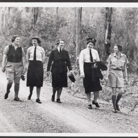 [Photograph: Margaret Blackwood with four other woman in uniform strolling on country road]