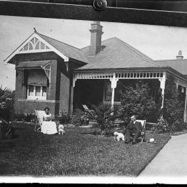 An unidentified man and woman in front of a brick Edwardian house.  Family name possibly Guppy.