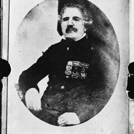 Portrait of a seated man wearing military medals.