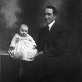 Studio portrait of Mr. C. Peterson and a baby.