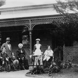 An  unidentified group of people in front of a verandahed timber residence.