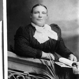 A large unidentified woman leaning on a balustrade.