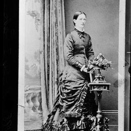 Studio portrait of a woman wearing a large spotted scarf.
