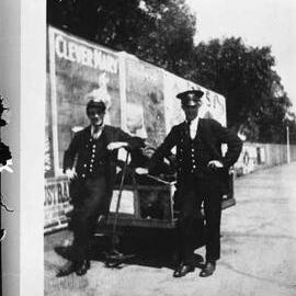 Railway porters and a luggage trolley on a railway platform.