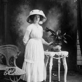 Studio portrait of  Miss May Pretty wearing a large hat.