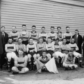 A Tungamah Football Club team posed in front of a timber building in 1926.