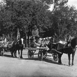 Decorated horse drawn wagons parading, possibly in  Benalla.