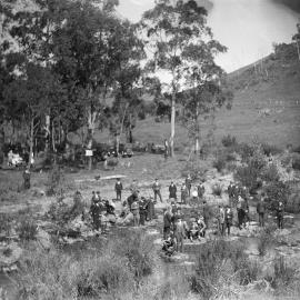 A group of men and cars at a creek in a rural environment, possibly near Benalla.