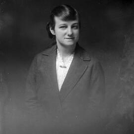 Portrait of an unidentified young woman wearing a brooch, white blouse and coat.