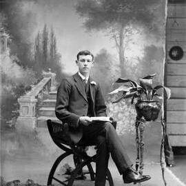 Studio portrait of a seated young man.