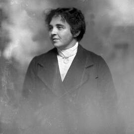 Portrait of an unidentified woman wearing a high-necked blouse and coat.