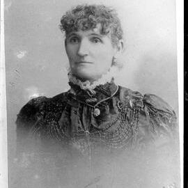 Portrait of an unidentified woman  wearing an elaborate dress with a high collar.