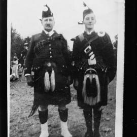 Two unidentified men dressed in Scottish highland costumes.