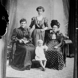 An unidentified group studio portrait of three women and a small child.