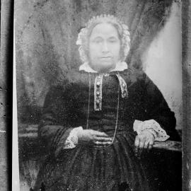 An unidentified seated woman wearing a bonnet.