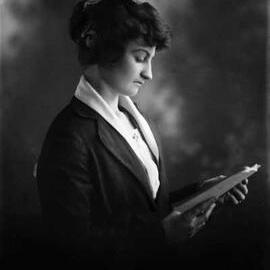 Studio portrait of Miss B. O’Brien reading a book.